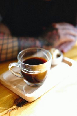 a cup of coffee in a clear glass double walled cup